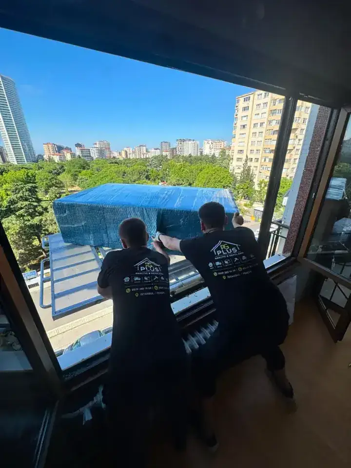 Balkon girişinde büyük eşyayla çalışan taşıma ekibi