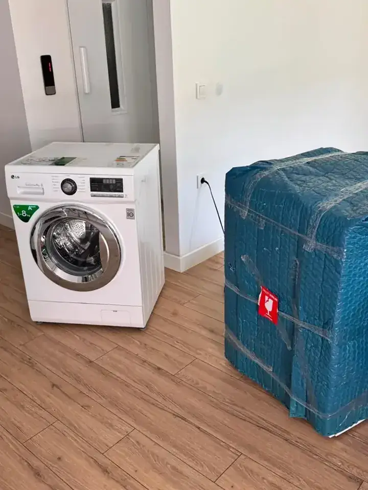 Çamaşır makinesi yanında ambalajlı mobilya — Nakliyat Plus gerçek iş arşivi